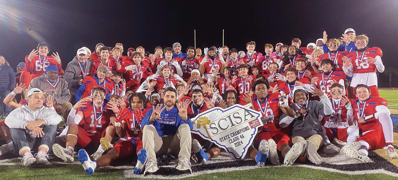 The Hammond Skyhawks, 2024 SCISA 4A Football State Champions: 0 Preston Springs; 1 Michael Tyler; 2 Jordan Boston; 3 Jack Croft; 4 Daylin Haltiwanger; 5 Jaiden Haltiwanger; 6 Adis Jamison; 7 Zay Mathis; 8 Charlie Allen; 9 Brewer LaMotte; 11 Jackson Ross; 12 Andrew Turner; 13 Jackson Bozaard; 14 Davis Brazell; 15 Ben Muela Kiser; 16 Wham Walker; 17 Everett Edens; 18 Jackson Waite; 19 Sam Heroman; 20 Wyatt Cantey; 21 Manning Redd; 22 Noah Goddard; 23 Blaze Barnes; 24 Immanuel Johnson; 25 Kinson Holland; 26 Leyton LaMotte; 27 Sullivan Epps; 28 Witt Williams; 29 McLean Robinson; 30 Dalton Stursberg; 31 Andrew Dennis; 33 Aspen Brooks; 34 Christopher Kirk; 40 Wyatt Kosciusko; 41 Charles Cannon; 42 Drew McCall; 44 Levi Myers; 45 Bubba Alexander; 51 James Lay; 52 John Stokes; 53 Jaliyl Jamison; 54 Walker Cason; 55 Jauris Shaw; 56 Henry Kaneft; 57 Ben Winkler; 66 Hudson Chastain; 68 James Meachem; 70 Jack Fuller; 71 Thomas Young; 73 McCall Daves; 75 Campbell Conley; 77 Parker Bowers; 79 Joel Starks; 80 Tripp Cohn; 81 Jack Thomas; 82 Bobby Peele; 84 Nicolas De La Haza Garcia; 92 Isaiah Best; Offensive Coordinator Rick Reetz; Running Game Coordinator/Athletic Director Jeff Barnes; Defensive Coordinator Hamp Smith; Assistant Head Coach Wynne Thomas; Assistant Coaches Bralyn Bennett, Gene Smith, Ken Watson, Jay Frye, Tyler Renew, and Jordan Thomas; Strength and Wellness Director Josh Ortegon; Athletic Trainer/Assistant Athletic Director Sonya Fuemmeler; Head Coach Jon Wheeler; and Head of School Andy North. Photos by Mike Maddock