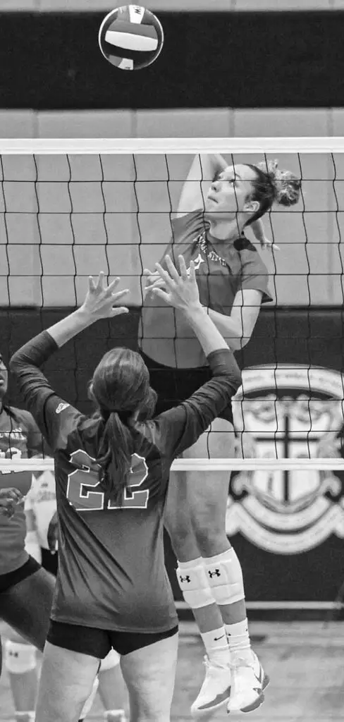 Cardinal Newman’s Khylie Remmenga pre- pares for a kill against Hammond’s Addison Sanders. Photos by Mike Maddock